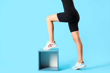 Young woman in cycling jumpsuit with box on blue backgroundの写真素材