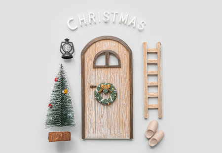 Beautiful composition with door, ladder, Christmas tree and decorations on gray backgroundの写真素材