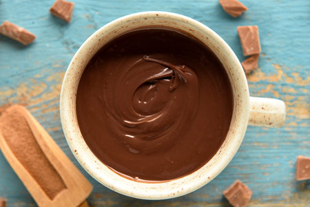 Cup of tasty melted chocolate on blue wooden backgroundの写真素材
