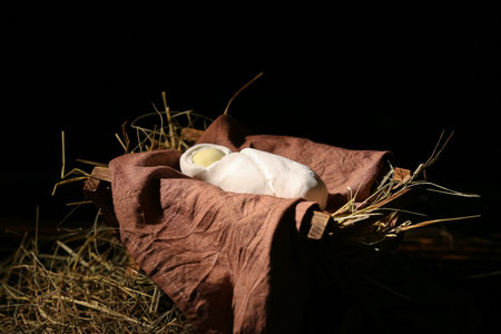 Manger with baby and hay on dark background. Concept of Christmas storyの写真素材