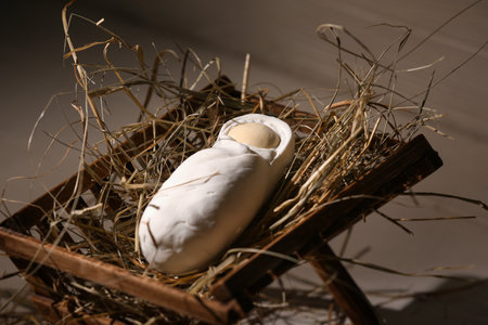 Manger with baby and hay on light wooden background. Concept of Christmas storyの写真素材