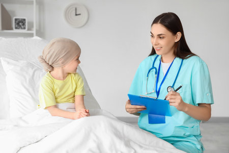 Little girl after chemotherapy with nurse in clinicの写真素材