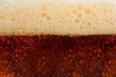 Dark beer with foam as backgroundの写真素材
