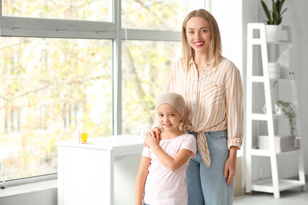 Little Asian girl after chemotherapy with her mother in clinicの写真素材