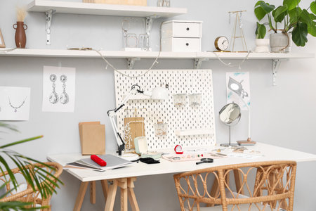 Sketches of stylish accessories with tools on jeweler table in workshopの写真素材