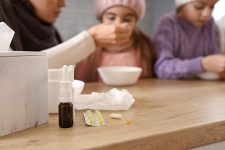 Medications on table of ill family in kitchen, closeup