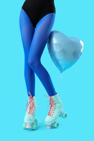 Balloon and legs of woman in roller skates on blue backgroundの写真素材