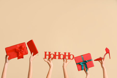 Female hands with wallet, shoe and Christmas gifts on beige background. New year shopping conceptの写真素材