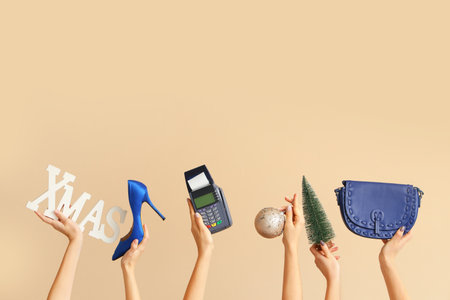 Female hands with payment terminal, bag and Christmas decor on beige background. New year shopping conceptの写真素材