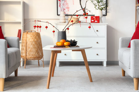 Coffee table with fresh tangerines, tea set and Chinese lanterns in festive living room. Chinese New Year celebrationの写真素材