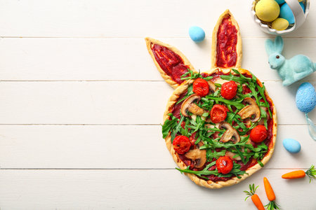 Composition with tasty pizza and painted Easter eggs on white wooden backgroundの写真素材