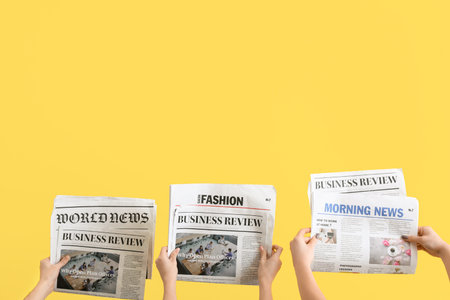 Women with newspapers on yellow backgroundの写真素材