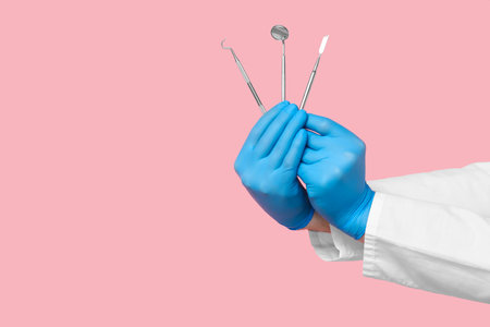 Dentist hands with dental tools on pink background. World Dentist Dayの写真素材