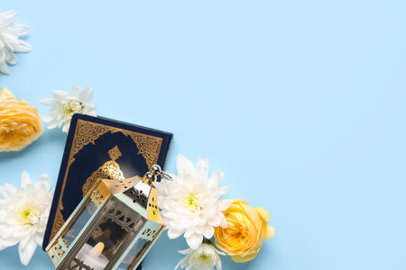 Muslim lamp with flowers and Koran on blue background. Ramadan celebrationの写真素材