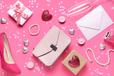 Woman accessories with envelope, gifts and decor on pink background. Valentine's Day celebrationの写真素材