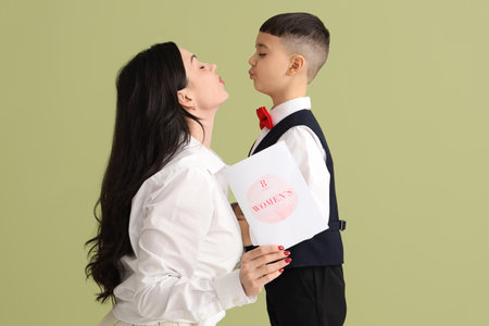 Cute little boy greeting his mother with International Women's Day on green backgroundの写真素材