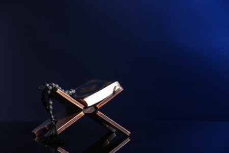 Rehal with Koran and prayer beads for Ramadan on dark blue backgroundの写真素材