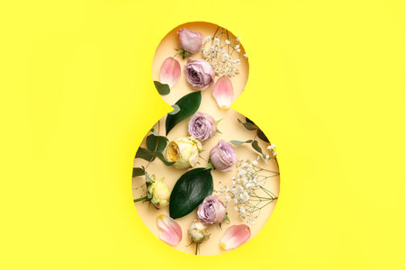 Cut paper in shape of figure 8 with different beautiful flowers on yellow background. International Women's Dayの写真素材