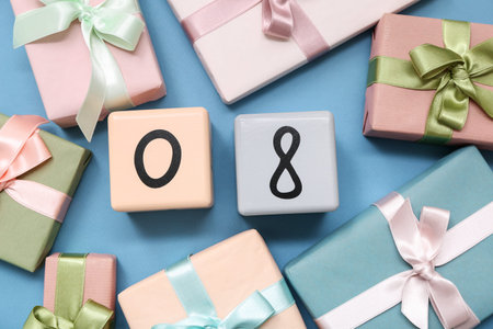 Cube calendar with date 08 and gift boxes on blue background. International Women's Day