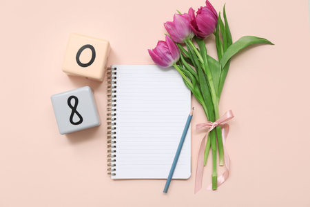 Cube calendar with date 08, beautiful purple tulips and notebook on pink background. International...