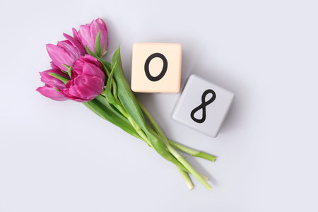 Cube calendar with date 08 and beautiful purple tulips on gray background. International Women's Day