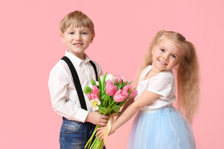 Cute little children with bouquet of beautiful tulips on pink background. International Women's Dayの写真素材