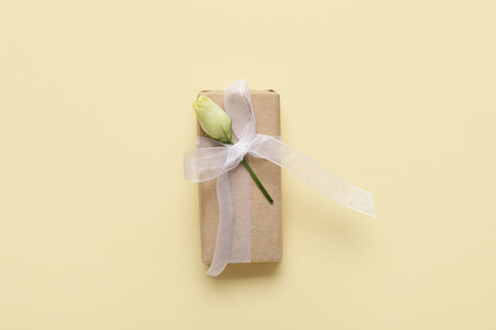 Gift box with beautiful white rose on yellow background. International Women's Dayの写真素材