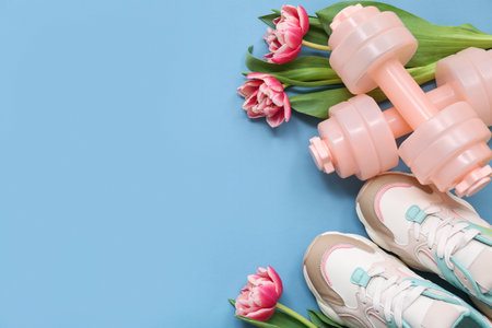 Composition with dumbbells, shoes and tulip flowers for International Women's Day on color backgroundの写真素材