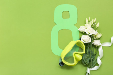 Composition with paper figure 8, snorkeling mask and flowers for International Women's Day on green backgroundの写真素材