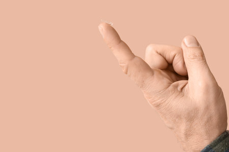 Male finger with contact lens on brown backgroundの写真素材