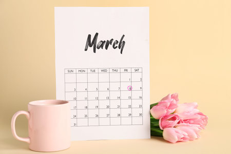 Calendar, cup of coffee and beautiful tulip flowers on beige background. International Women's Day celebrationの写真素材