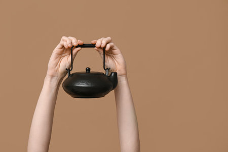 Woman with teapot on brown backgroundの写真素材