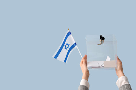 Hands holding ballot box and flag of Israel on light background. Election conceptの写真素材