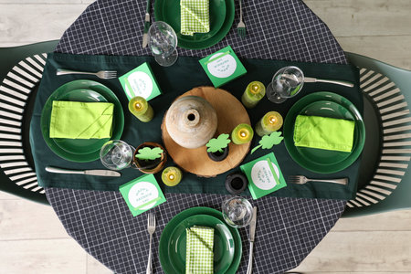 Festive table serving with burning candles and clovers, top view. St. Patrick's Day celebrationの写真素材