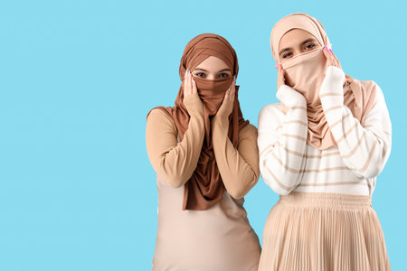 Young Muslim women in hijab on blue backgroundの写真素材