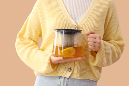Young woman with teapot on beige background, closeupの写真素材