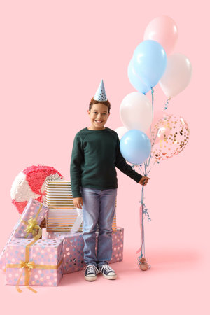 Little African-American boy in party hat with balloons and Birthday gifts on pink backgroundの写真素材