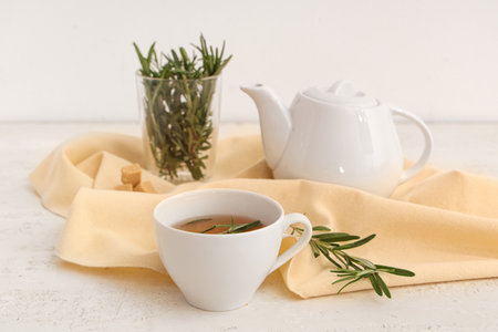 Teapot and cup of hot rosemary tea on white backgroundの写真素材