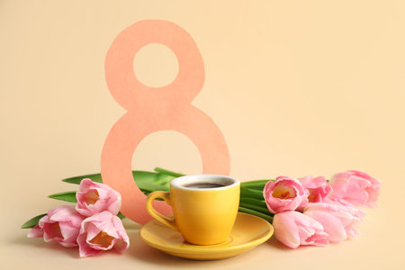 Tulip flowers with cup of coffee and paper figure 8 on beige background. International Women's Day...