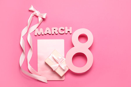 Date 8 MARCH made of paper with bow, notebook and gift box on pink background. International Women's Dayの写真素材