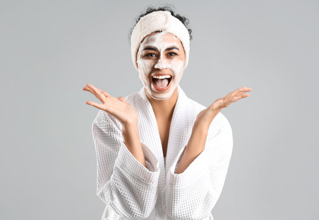 Surprised young African-American woman with cleansing foam on light backgroundの写真素材