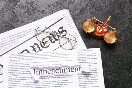 Newspapers with eyeglasses, scales of justice and word IMPEACHMENT on black grunge backgroundの写真素材