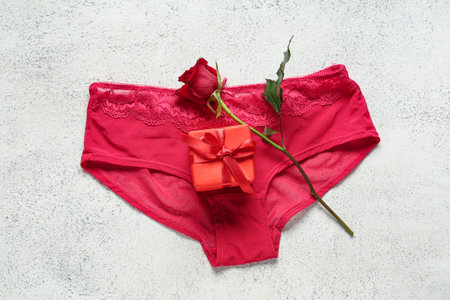Sexy red panties with gift box and rose on grunge white background. Valentine's Day celebrationの写真素材