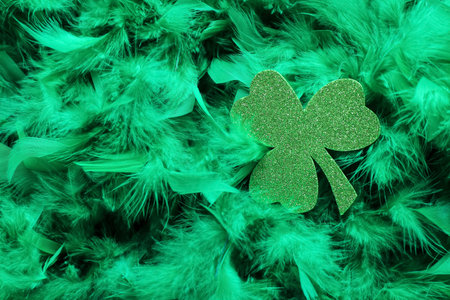 Paper clover on green feathers. St. Patrick's Day celebration