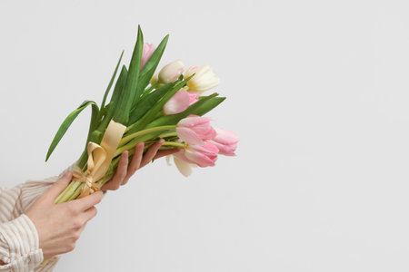 Female hands with bouquet of beautiful tulips on white background. International Women's Dayの写真素材