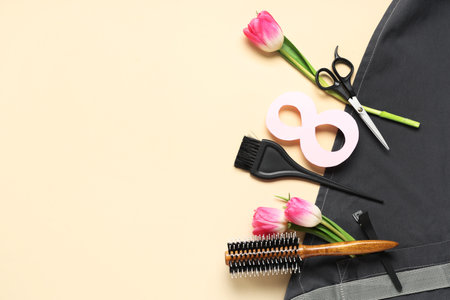 Composition with hairdresser's supplies, apron and tulip flowers on color background. International Women's Dayの写真素材