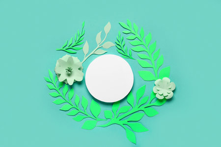 Paper sheet with beautiful flowers and leaves on green backgroundの写真素材