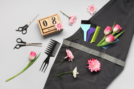 Composition with hairdresser's supplies, spring flowers and calendar with date of International Women's Day on gray backgroundの写真素材