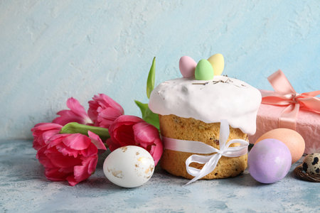 Composition with delicious decorated Easter cake, flowers and painted eggs on color background