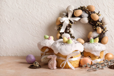 Composition with delicious decorated Easter cakes, porcelain bunny and painted eggs on color backgroundの写真素材